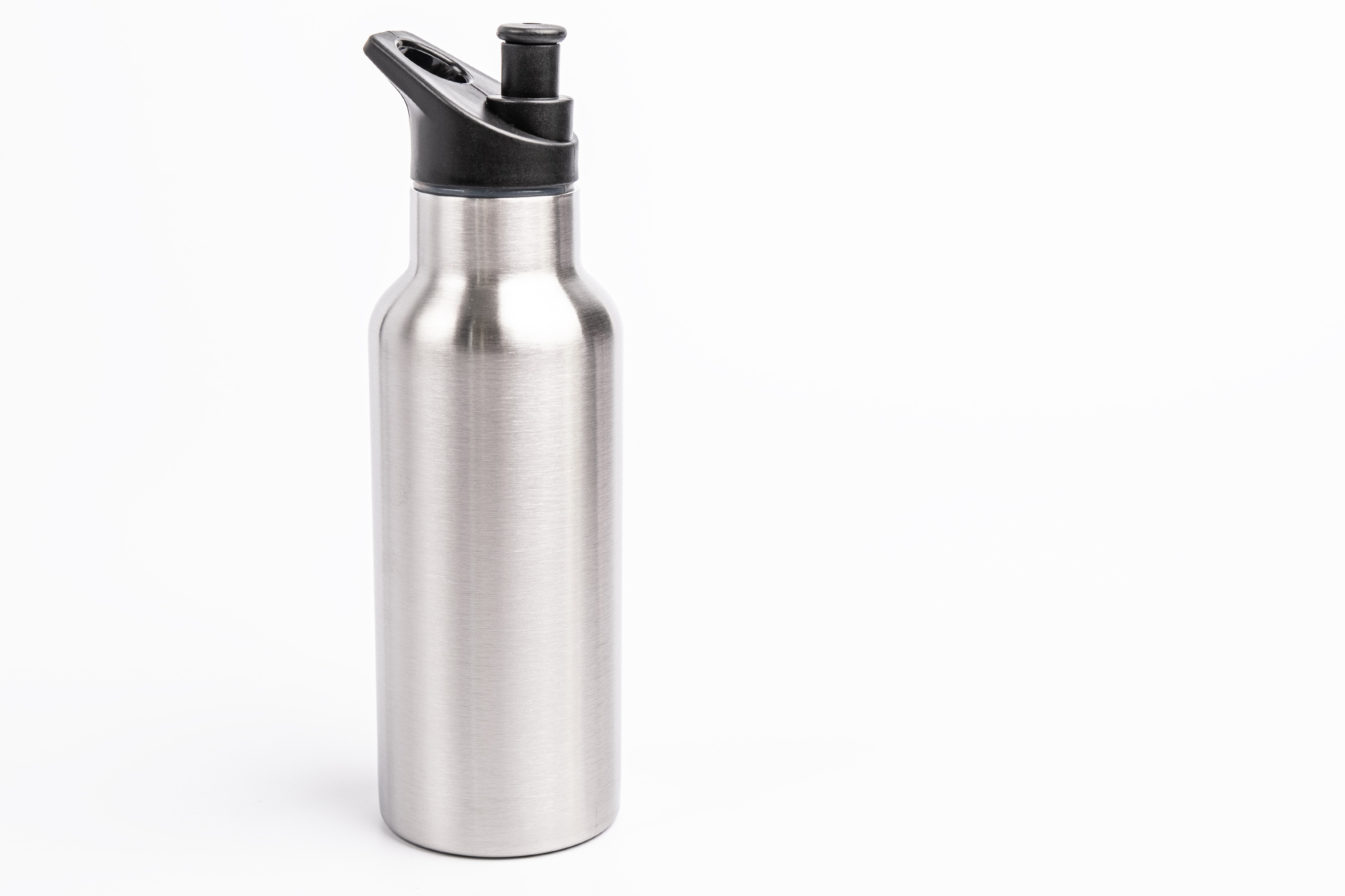 Geschlossene Edelstahl-Trinkflasche mit schwarzem Pop-up-Deckel aus Kunststoff, auf weißem Hintergrund fotografiert.