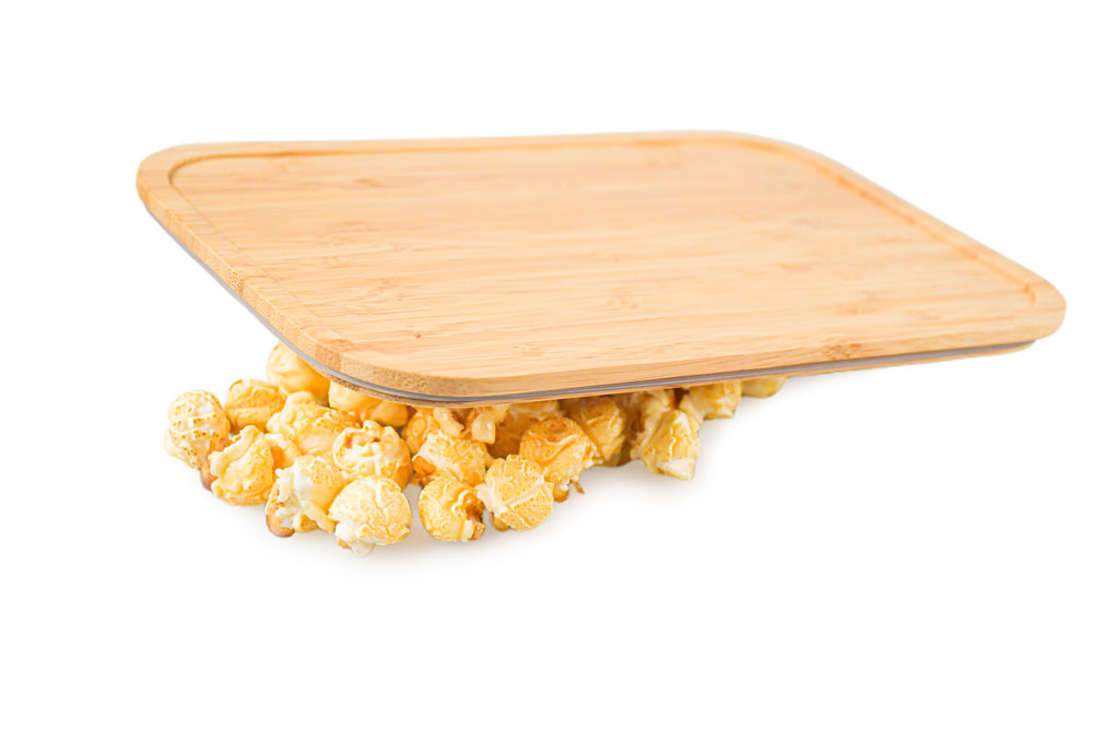Bambusdeckel auf weißem Hintergrund mit Popcorn – dekorativ dargestellter Ersatzdeckel für Lunchbox