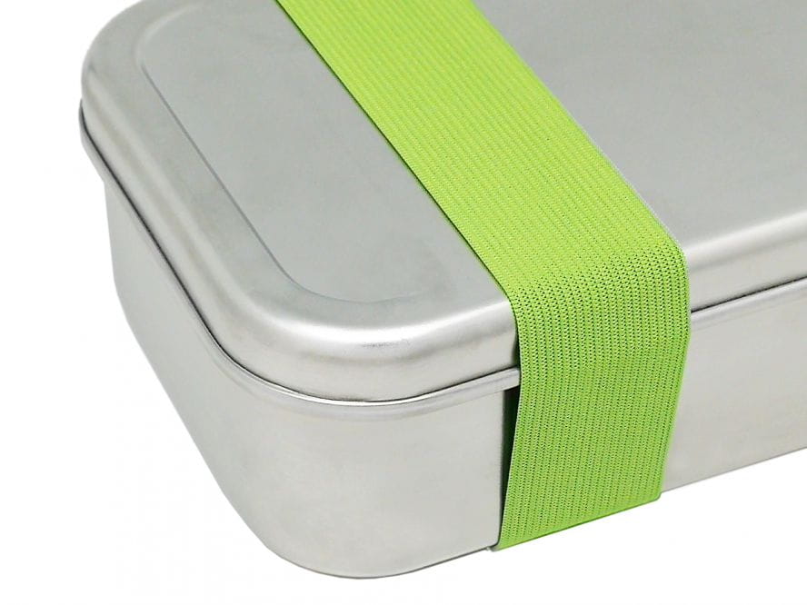 Edelstahl Lunchbox mit aufgesetztem Deckel und grünem Gummiband zur sicheren Fixierung, Detailaufnahme.