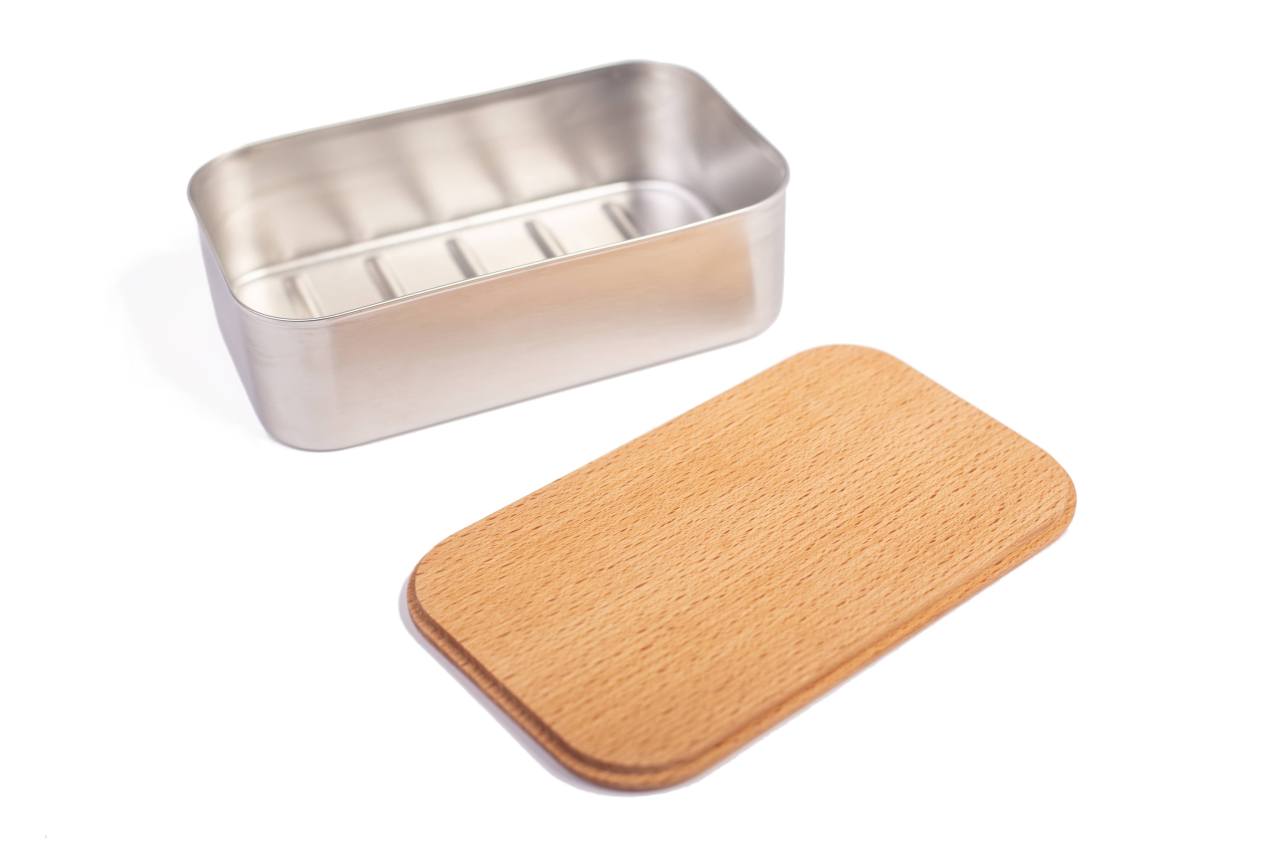 Geöffnete rechteckige Lunchbox aus Edelstahl mit abgenommenem Buchenholzdeckel, auf weißem Hintergrund dargestellt.