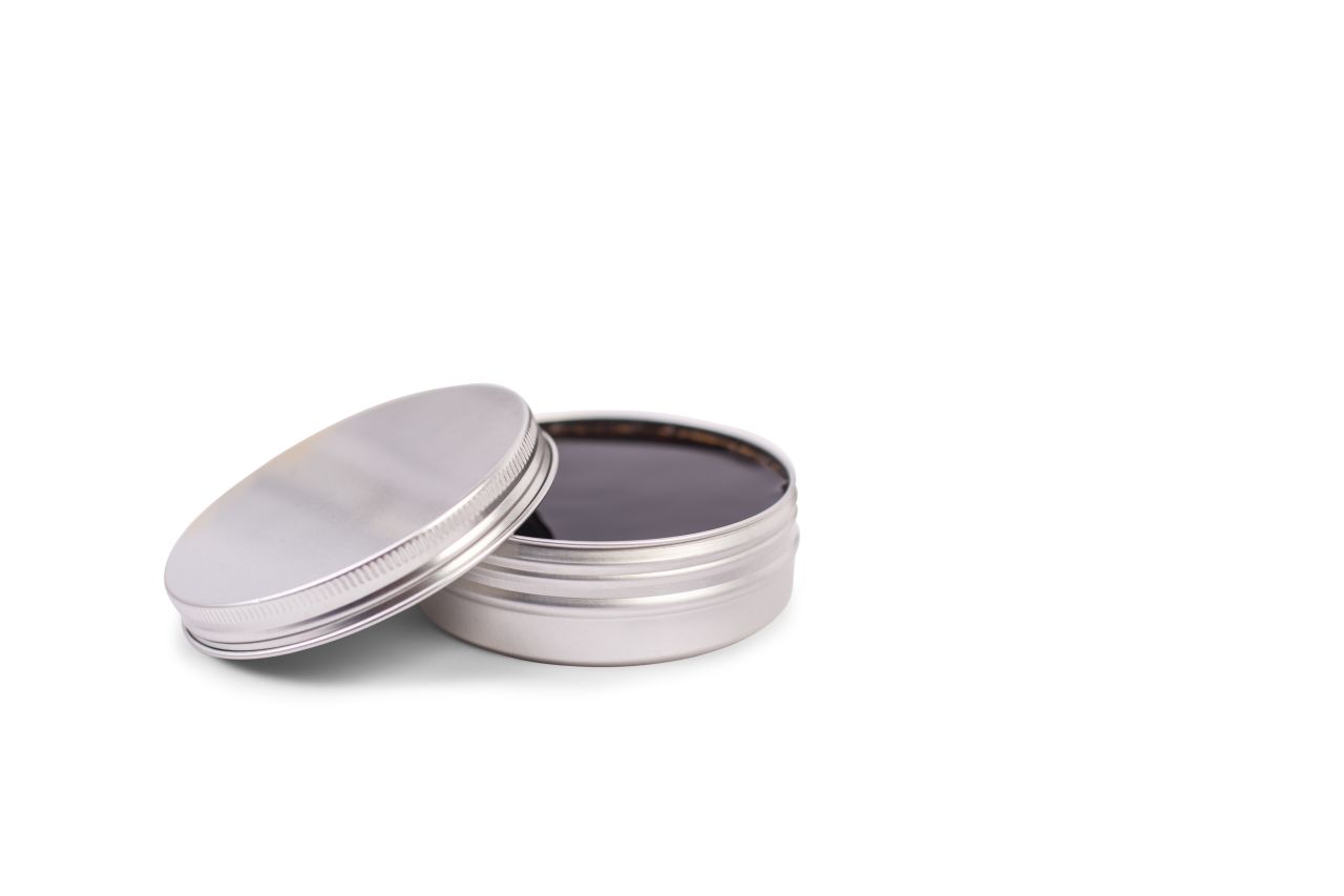 Geöffnete silberne Aluminiumdose mit 125 ml Fassungsvermögen, befüllt mit einer dunklen, möglicherweise öligen Substanz. Der Deckel ist leicht angelehnt und der Hintergrund ist weiß.